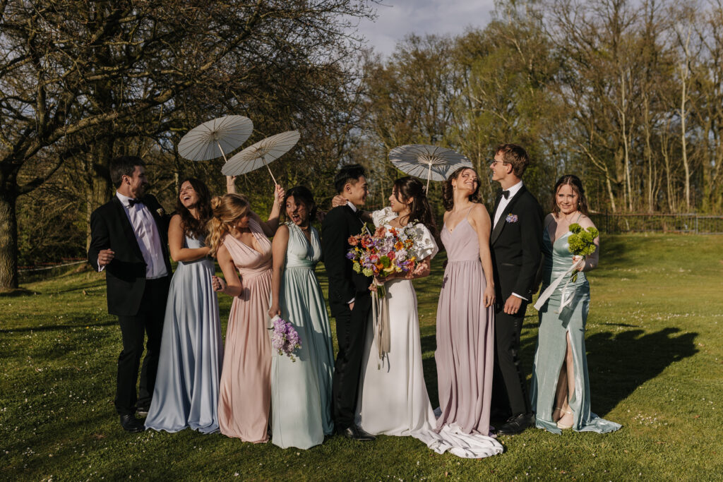 Veronika Rodriguez Hochzeitsplanung für Mülheim an der Ruhr und Umgebung, Brautpaar mit den Hochzeitsgästen auf der Wiese
